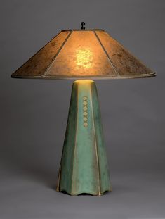 a lamp that is sitting on top of a white surface with a brown and blue shade