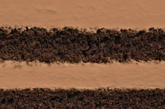 two layers of chocolate cake with white and brown frosting in the middle, on top of each other