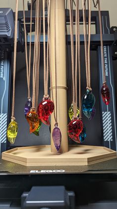 several different colored glass hearts hanging from a wooden pole in front of a server rack