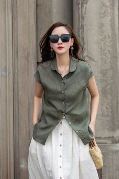 Elevate your everyday style with our military green short-sleeve linen blouse. Crafted from high-quality linen fabric, this blouse offers a comfortable and breathable fit. The military green color exudes a sense of versatility and pairs well with both neutral and bold colors. The short sleeves provide a relaxed and laid-back look, perfect for casual occasions. The button-up front adds a touch of sophistication, making it suitable for office settings as well. Embrace the effortlessly chic vibe of Khaki Solid Color Summer Blouse, Casual Olive Tops With Buttons, Olive Short Sleeve Top For Summer, Casual Olive Top With Buttons, Khaki Linen Short Sleeve Tops, Khaki Short Sleeve Blouse With Pockets, Green Short Sleeve Blouse With Button Closure, Green Short Sleeve Blouse With Buttons, Olive Button-up Summer Top