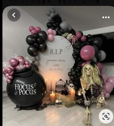 a halloween scene with balloons and decorations in the shape of a skeleton sitting next to a black caulder