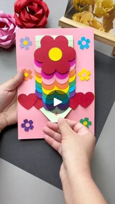 someone is making a card with flowers and hearts