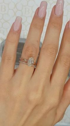 a woman's hand with a ring on her finger and a diamond in the middle