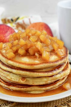 a stack of pancakes with apples on top