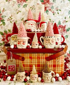 there are many gnomes in the basket with santa's hats on it and other decorations around them