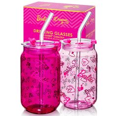 two pink glass jars with straws in them