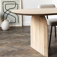 a wooden table and chairs in a room with wood flooring that looks like herringbone tiles