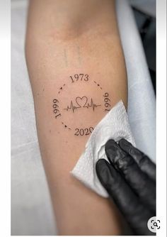 a woman's arm with a heartbeat tattoo on it, and the date is written in cursive writing