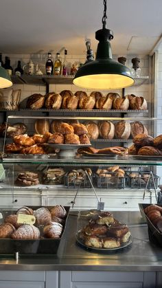 a bakery filled with lots of different types of breads and pastries on display