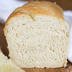 a loaf of white bread sitting on top of a wooden cutting board