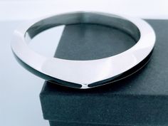 "Beautiful Retro Modernist Inspired Mexico 925 Silver Black Onyx Enamel Inlay Bangle. Featuring thick wide polished silver triangle inlaid with black onyx. Lightly cleaned ready to wear Markings:  925 Mexico  Measurements: 7 7/8\" inside circumference,  2 1/2\" inside diameter, 1/4\" wide at narrowest point and over 1/2\" at widest point.  Total Weight: 51.26 grams Condition: Good Vintage pre-owned condition, ready to wear with light wear.  Photos of actual item.   Please review the photos for v Modern Black Sterling Silver Bracelet For Formal Occasions, Modern Black Enamel Bracelets For Formal Occasions, Modern Black Bangle Jewelry, Modern Black Bangle As Gift, Elegant Handmade Black Bangle, Modern Black Bangle, Modern Black Enamel Bracelet Jewelry, Modern Black Round Bangle, Modern Black Enamel Jewelry Bracelet