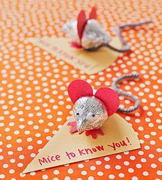 two little mouses are sitting on top of a table with red and white polka dots