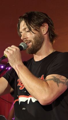 a bearded man singing into a microphone