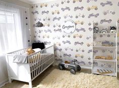 a baby's room with a crib and toy cars on the wall next to it