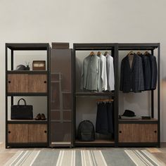 an open closet with clothes hanging on the shelves and shoes sitting on the floor next to it