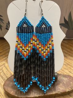 the beaded earrings are made from black, yellow and blue beads with fringes