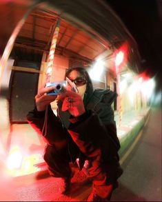 a woman taking a selfie with her camera in front of a mirror at night