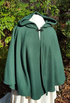 This short cloak is delightfully soft and comfortable. It's long enough to reach the back of the hand, keeping you warm but keeping your hands available when needed. It has a full hood and closes with your choice of a matching cloth frog clasp or a heart shaped metal clasp. Click through the pictures to see the options. This cloak is great for a costume piece or a cozy jacket, great for Spring, Fall, or over air conditioned buildings. Your cloak will measure about 30 inches in length. This listi Green Cape Outerwear For Fall, Green Fall Cape Outerwear, Green Cape For Fall, Hooded Green Cape For Fall, Green Hooded Cape For Fall