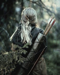 a woman with long hair holding two arrows