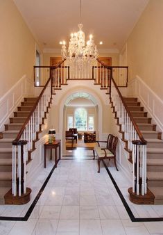 an elegant entry way with chandelier and stairs leading up to the second floor