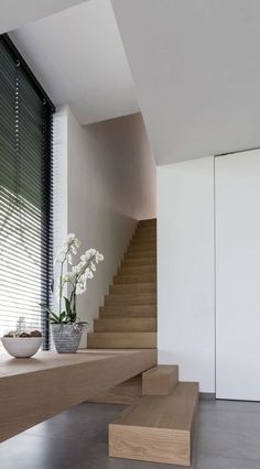 there is a vase with flowers on the top of this set of stairs in front of a window