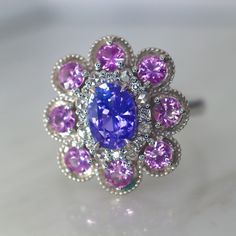 Lavender Sapphire Halo Ring I created with flawless precision cut unheated vivid Lavender sapphires and unheated pink sapphire. This ring's color combo is inspired by the paintings of lilacs by Claude Monet. The inner halo is made of both rose-cut and brilliant cut diamonds. The two kinds of diamonds sparkles so differently. The rose cut looks like the fresh morning dew on the flower petal, and the brilliant cut diamonds are the beautiful morning sunshine. I altered the design to have round edge Purple Pink Sapphire Promise Ring, Purple Pink Sapphire Ring With Center Stone, Fine Jewelry Pink Sapphire Ring In Purple, Heirloom Purple Sapphire Ring For Anniversary, Purple Multi-stone Sapphire Ring, Fine Jewelry Purple Sapphire Ring With Accent Stones, Gift Purple Pink Sapphire Ring, Purple Sapphire Ring With Halo Setting, Tanzanite Gemstone With Center Stone As Gift