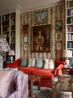 a living room filled with furniture and bookshelves next to a painting on the wall