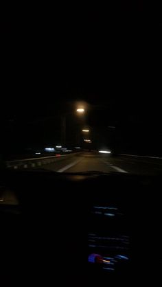 a car driving at night in the dark