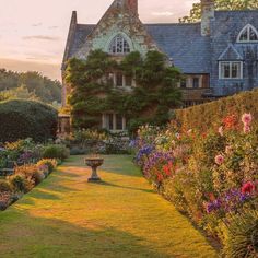 a large house with lots of flowers in the front yard