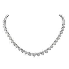 This riviera necklace features 6.84 carats of round F-G VS pave diamonds fashioned into heart shapes. 44.8 grams total weight. 7.5 inch chain drop. Viewings available in our NYC showroom by appointment. Luxury Heart Cut Necklace With Pave Setting, Luxury Heart Cut Necklaces With Pave Setting, Elegant Heart-shaped Tennis Necklace, Heart Diamond Necklace, Pave Necklace, Heart Necklace Diamond, Heart Shaped Diamond, Diamond Fashion, Diamond Heart