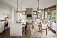 a kitchen and dining room are shown with wood floors, white cabinets, and marble counter tops