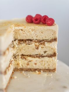 two layers of cake with white frosting and raspberries on the top slice