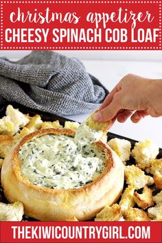 a person dipping something into a bread bowl