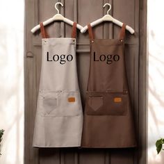 two aprons hanging on a door hanger with the word logo printed on them