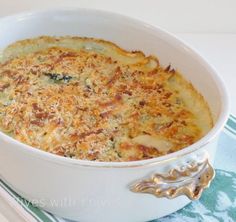 a casserole dish with cheese and other toppings in a white bowl on a table