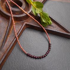 This is a dainty beaded necklace in a combination of small dark red garnet stones and tiny peach pink seed beads with a subtle shimmery finish. The stones are separated from the glass beads by small solid sterling silver etched Hill Tribe beads. The necklace is finished with a solid sterling silver spring ring clasp. You can add an optional silver plated 2-inch extender chain for added versatility or peace of mind if this is a gift. This modern necklace gives you a fun pop of color. It's lightweight and the optional extender chain would make it easy to layer with some other faves. Necklace length: 16 inches; optional 2" extender chain available Your necklace will arrive in an eco-friendly Kraft paper gift box. Beaded Necklace Collection: https://www.etsy.com/shop/BonArtsStudio?ref=seller-p Burgundy Beaded Necklaces With Round Beads As Gift, Handmade Burgundy Necklaces With Round Beads, Handmade Burgundy Beaded Necklaces As Gift, Handmade Burgundy Beaded Necklaces For Gifts, Rose Gold Necklaces With Round Tiny Beads, Amber Beaded Necklaces With Spacer Beads As Gift, Layering Jewelry, Modern Necklace, Necklace Collection