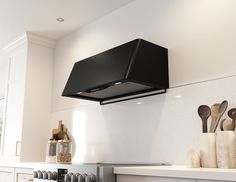 a stove top oven sitting inside of a kitchen next to wooden spoons and utensils