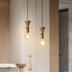 three light fixtures hanging from the ceiling in a room with marble counter tops and white walls