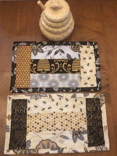 two placemats and a tea pot on a table with a wooden floor in the background