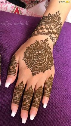 a woman's hand with henna tattoos on it