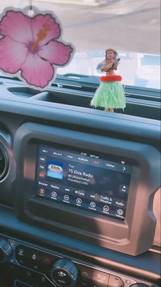 an image of a car radio with a flower on it's dash board and a sticker in the center