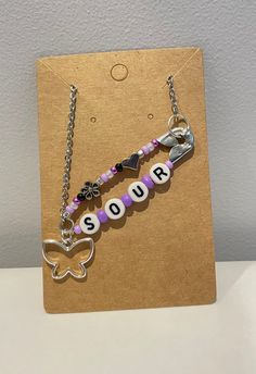 Inspired by Olivia Rodrigo's debut studio album "SOUR", this safety pin necklace is hand beaded with glass seed beads, zinc alloy charms, and letter beads. Secured with jump rings to a silver stainless steel chain with a circumference of 45 +5cm, this necklace is perfect for any Livies out there, or those who just like the punk style of safety pin jewelry with a message to the world. Jewelry Care Guide to Increase Longevity and Quality: - Store in a cool, dry place away from sunlight when not we Safety Pin Necklace, Safety Pin Jewelry, Pin Necklace, Fun Jewelry, Letter Beads, Pin Jewelry, Punk Style, Glass Seed Beads, Olivia Rodrigo