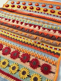 a multicolored crocheted blanket with sunflowers and circles on it