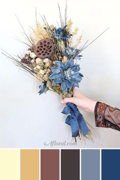 a person holding a bouquet of flowers in front of a white wall with color swatches