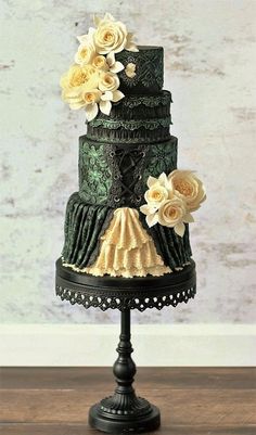 a three tiered cake with white flowers on it's top and green icing