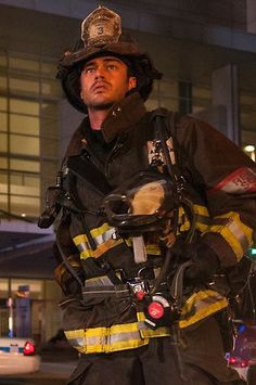 a firefighter standing in the street with his bike