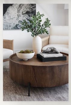 a coffee table with a bowl on it in front of a couch and two chairs