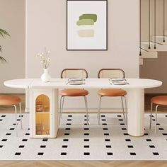 a dining room table with four chairs and a vase