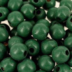 green beads with holes in them on a white surface