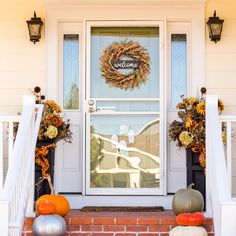 front door decorated for fall with pumpkins and flowers on the steps to the entrance